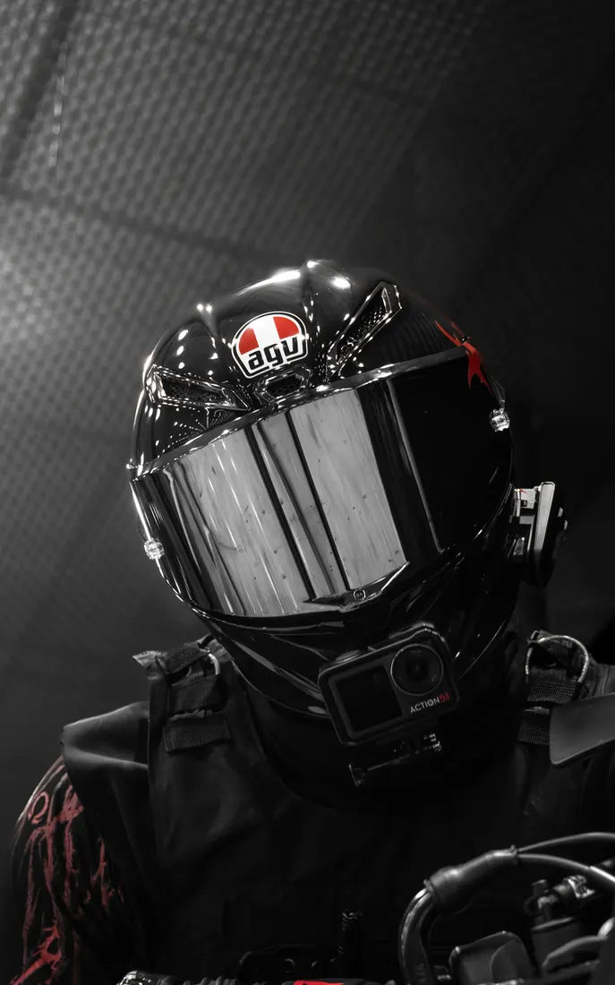 Pilote au casque AGV noir avec sticker cover Italie sur le logo AGV