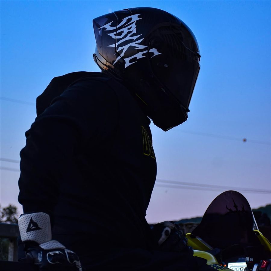 Motard et casque stické au coucher du soleil
