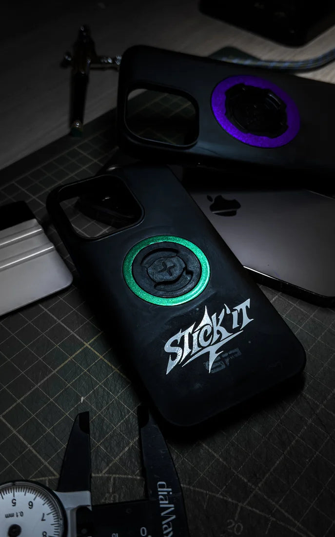 Coques de téléphone Quad Lock avec stickers anneau vert et violet sur un établi