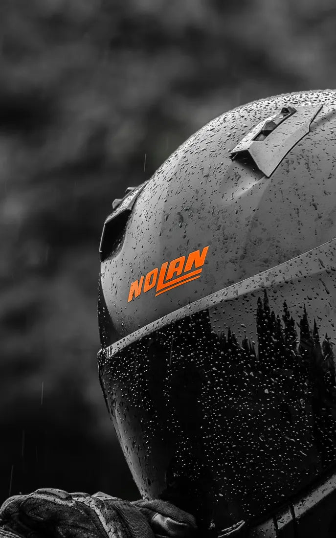 Sticker logo Nolan couleur Orange sur un casque Nolan sous la pluie