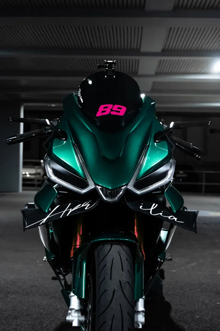 Aprilia verte avec numéro de course en sticker couleur Rose fuchsia sur la bulle