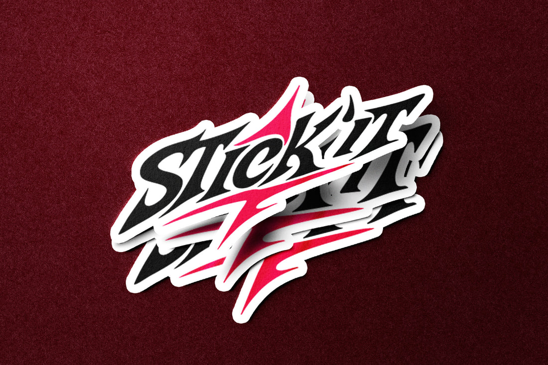 Sticker Stick'it rose et blanc posé sur un fond rouge texturé