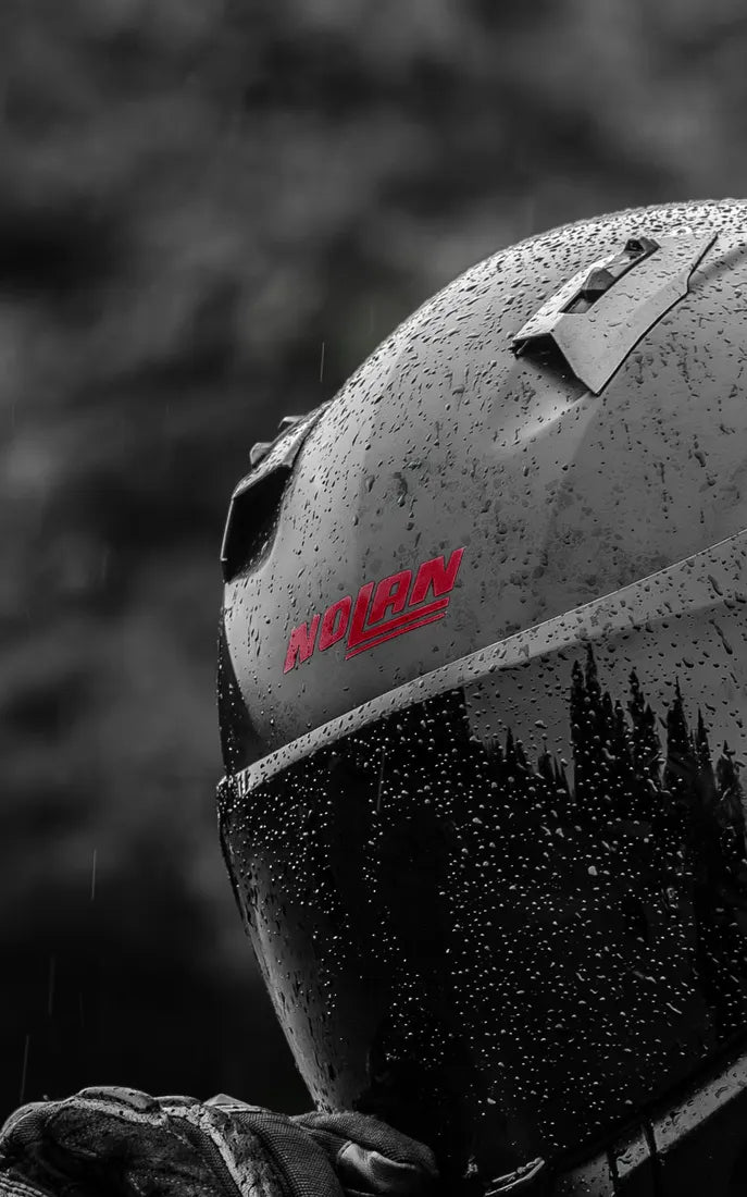 Sticker logo Nolan couleur Bordeaux sur un casque Nolan sous la pluie