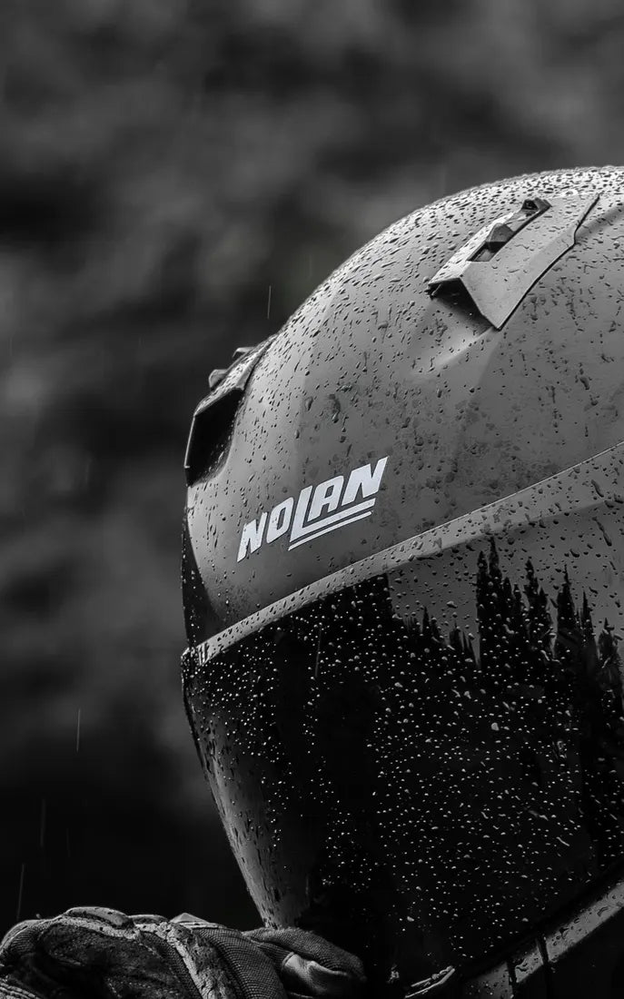 Sticker logo Nolan couleur Gris métallisé sur un casque Nolan sous la pluie